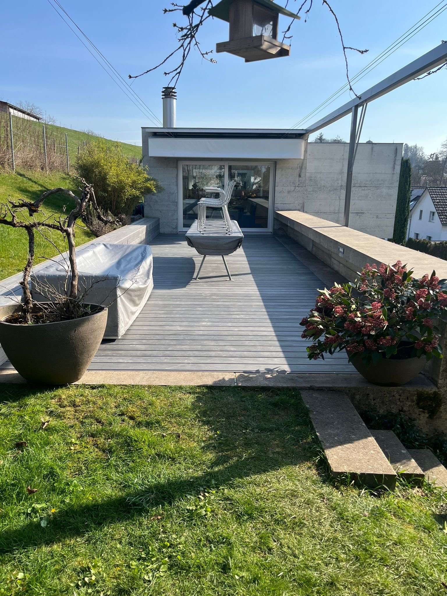 Accoya Grey Holzterrasse mit integrierter Sitzbank, unsichtbarer Clipbefestigung und langlebiger Aluminium-Unterkonstruktion.