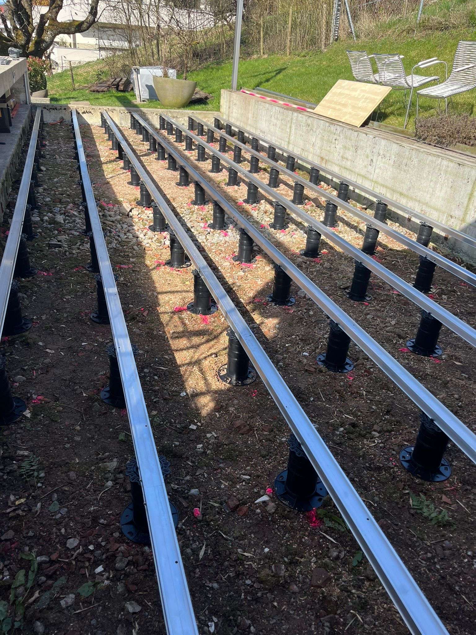 Accoya Grey Holzterrasse mit integrierter Sitzbank, unsichtbarer Clipbefestigung und langlebiger Aluminium-Unterkonstruktion.